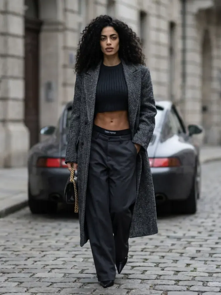 Curly Brunette mit Trenchcoat vor Porsche - Wildwuchs Friseur Linz Lookbook